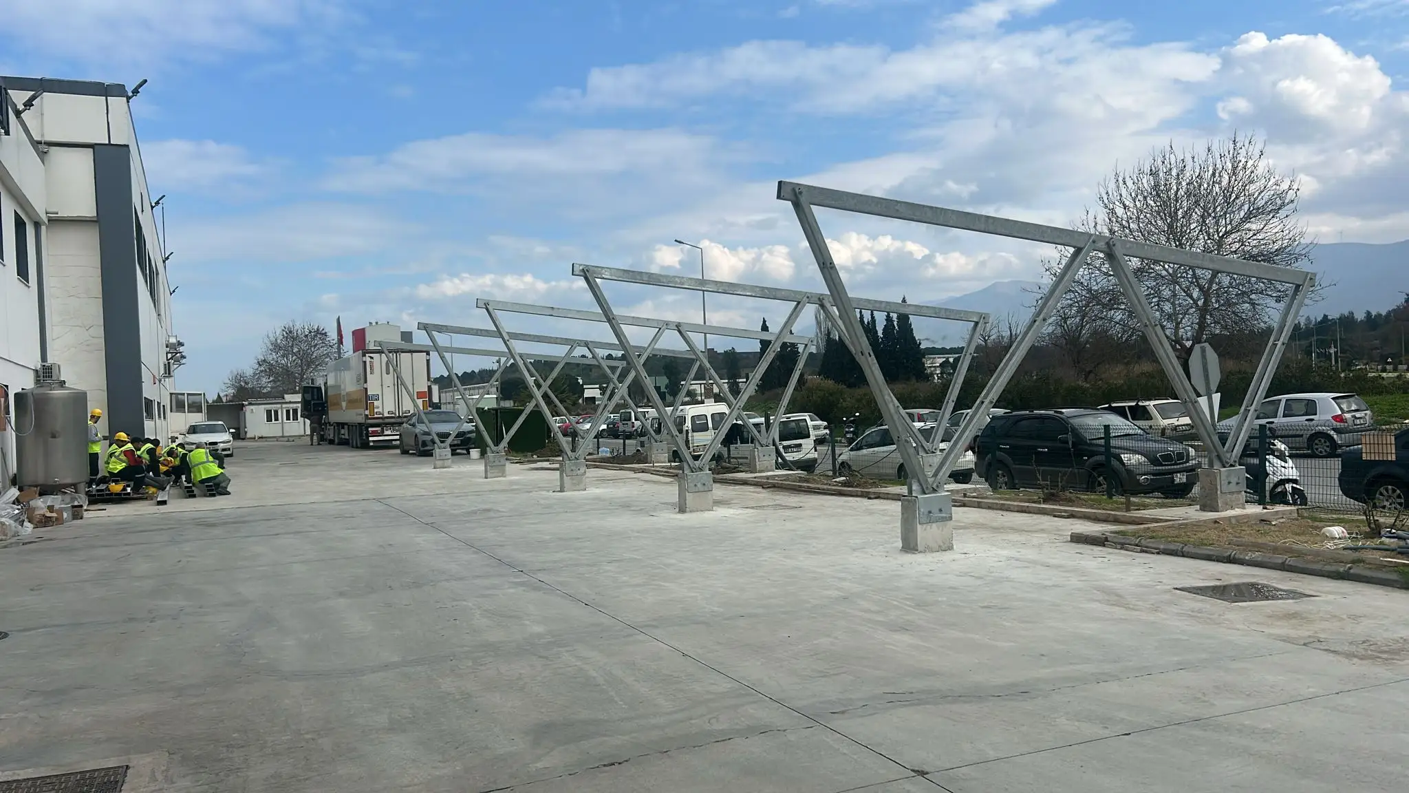 Tamamlanmış çok araçlı carport sistemi ve altındaki araçlar
